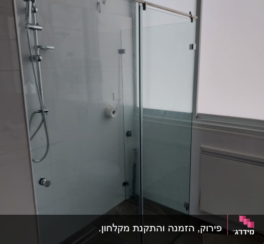 מקלחון זכוכית פינתי עם דלת הזזה ומסילה עליונה בחדר רחצה